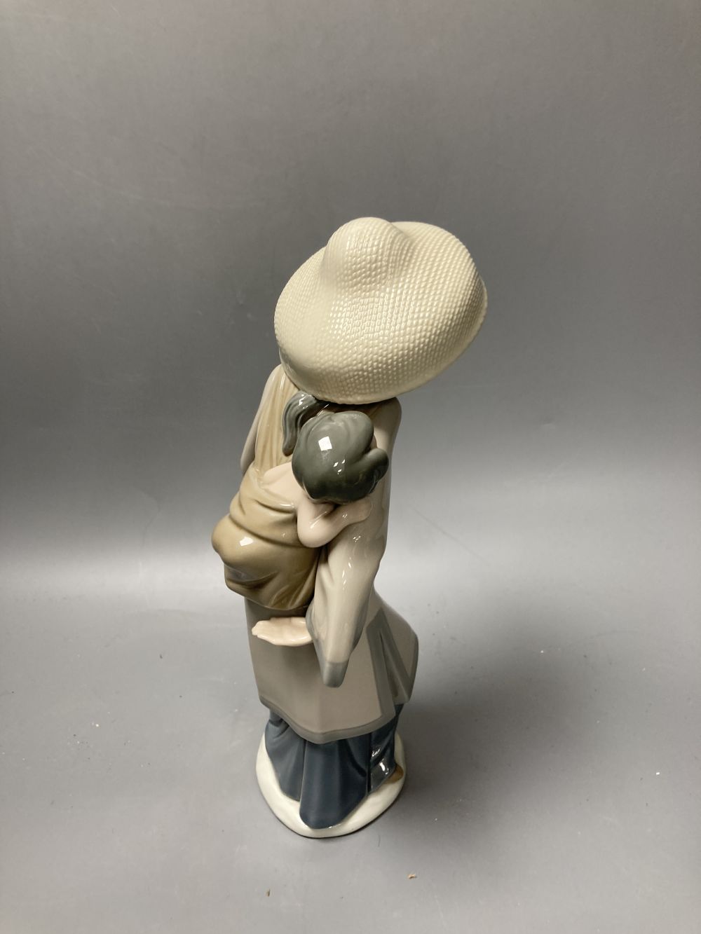 Two Lladro porcelain figures and a Royal Copenhagen model of a seal, tallest 26cm